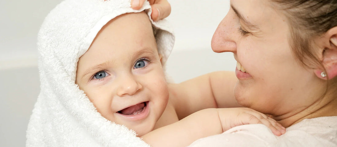 Sicheres Duschen mit Baby-Anleitung, die die sanfte Handhabung des Duschkopfs zeigt